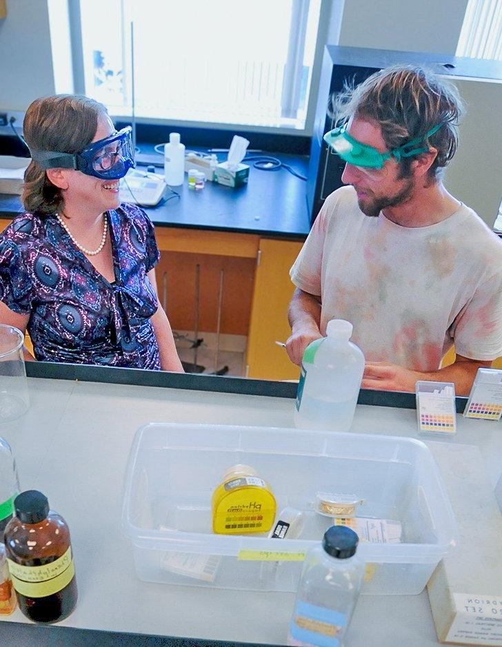 a professor chats with a student in a science lab